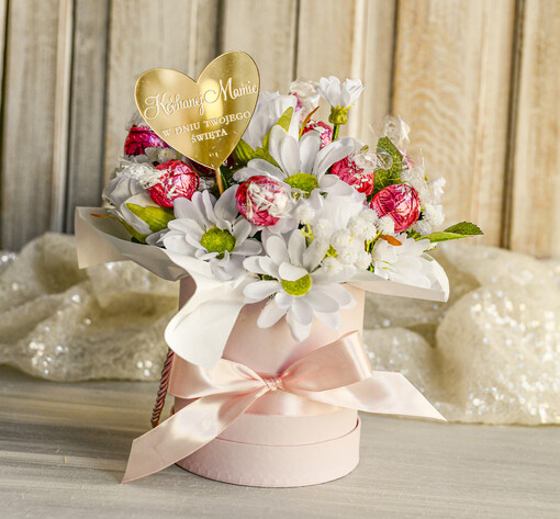  flowerboxy, box ze słodyczami  Elegancki flowerbox z sztucznymi kwiatami i słodyczami to wyjątkowy prezent dla mamy. Piękna kompozycja w ozdobnym pudełku – gotowy upominek na każdą okazję.