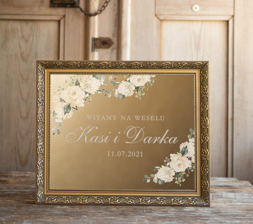 Plany stołów złote na lustrze  złota tablica glamour witamy na weselu białe napisy i kwiaty na złotym lustrze w ozdobnej ramie wasze imiona i data 0