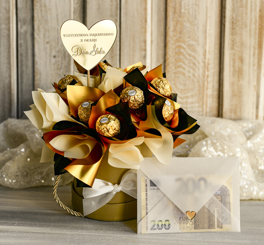  Prezenty dla Młodej Pary  flowerbox, kartki z życzeniami, pudełka na prezenty Elegancki flowerbox ze słodyczami to wyjątkowy prezent dla Młodej Pary. Piękna kompozycja w ozdobnym pudełku tworzy elegancki i gotowy do wręczenia upominek na ślub0