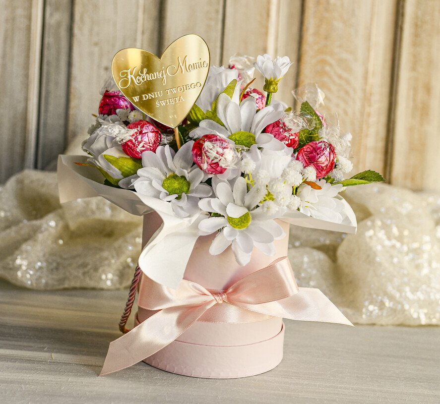 Prezenty dla Mamy flowerboxy, box ze słodyczami  Elegancki flowerbox z sztucznymi kwiatami i słodyczami to wyjątkowy prezent dla mamy. Piękna kompozycja w ozdobnym pudełku – gotowy upominek na każdą okazję.1